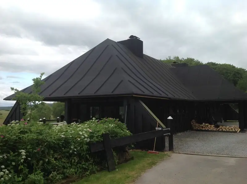 Sort hus med nyt tagpaptag og carport
